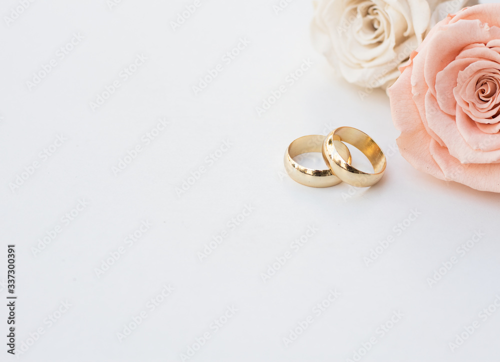 Chiếc nhẫn cưới và hai đóa hoa hồng vàng trên nền trắng tạo nên một vẻ đẹp thanh lịch và tinh tế. Bức ảnh của chúng tôi sẽ làm nổi bật những giá trị tinh thần và cảm xúc trong ngày trọng đại của bạn. 
