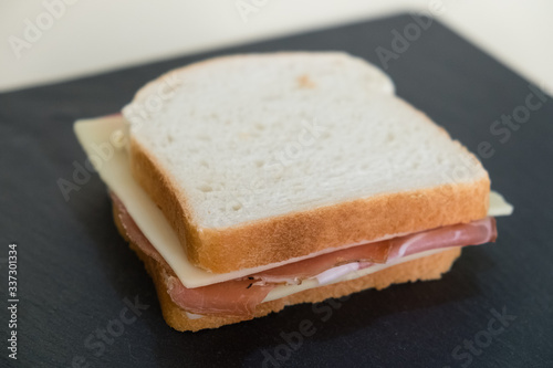 Toast  slices of white bread stuffed with speck and cheese.