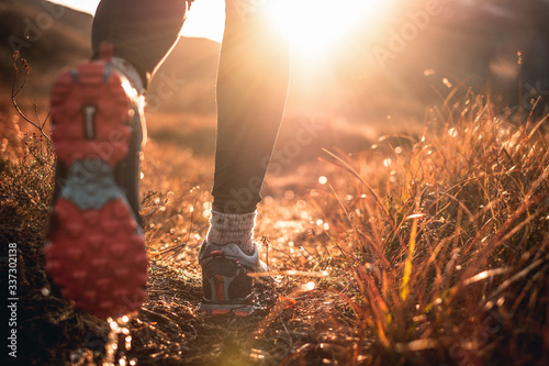 Fotografija Running in the mud. Blurred shoes and grass. Foot in the mud
