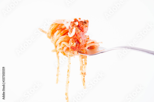 Spaghetti bolognese sprinkled with cheese on a fork on a white background