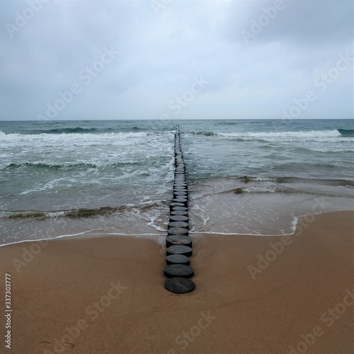 Array of wooden logs in the sea.