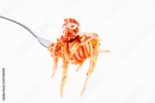 Spaghetti bolognese sprinkled with cheese on a fork on a white background