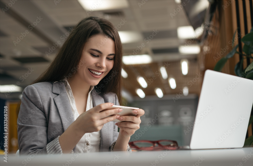 Happy emotional woman using mobile phone, communication, watching movie, reading news. Freelancer working online, sitting at workplace Happy emotional woman using mobile phone, communication, watching movie, reading news. Freelancer working online, sitting at workplace