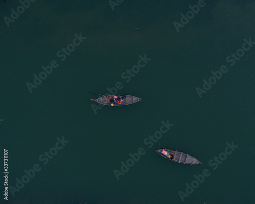 Aerial top down view of long tail boats with tourists floating on Thu Bon River in Hoi An old town, Vietnam. Minimalism. Vietnamese culture.