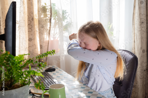 Caucasian young girl sneezing,coughing into her sleeve or elbow to prevent spread Covid-19, virus,sick girl has flu,fever covering nose,mouth with her arm from dusty,allergies,air pollution