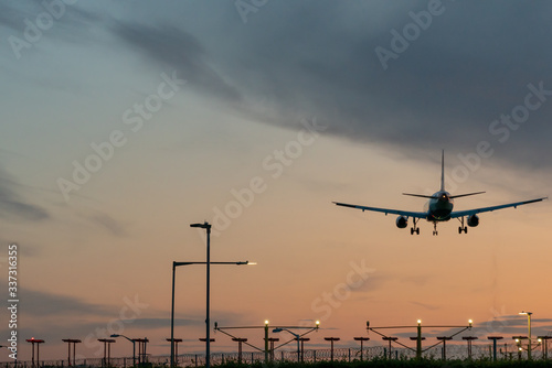Airplane taking off from the airport runway at the sunset. © CupOfSpring