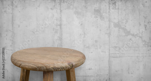 Antique wooden bar stool on background of grungy concrete wall photo