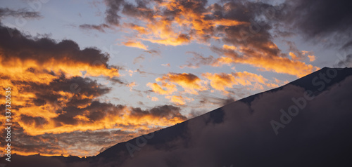 Fototapeta Naklejka Na Ścianę i Meble -  (Selective focus) Stunning view of the Mount Rinjani during a beautiful and dramatic sunset. Mount Rinjani (Gunung Rinjani) is an active volcano and the second highest mountain in Indonesia.