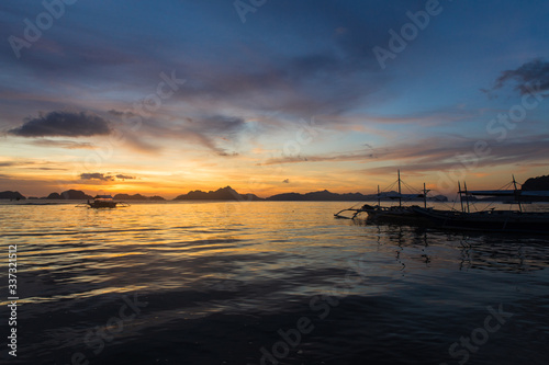traditional philipinian boat silhouette in El Nido, Palawan with colored sunset on background