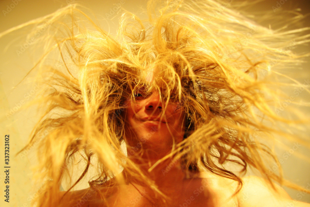 Funny portrait of a young guy with long tousled hair. The man is smiling. Horizontal. Funny portrait of a young guy with long tousled hair. The man is smiling. Horizontal.