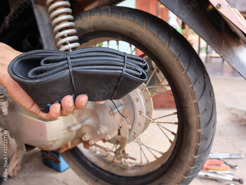 Mechanic prepares for changing inner tubes in motorcycle.