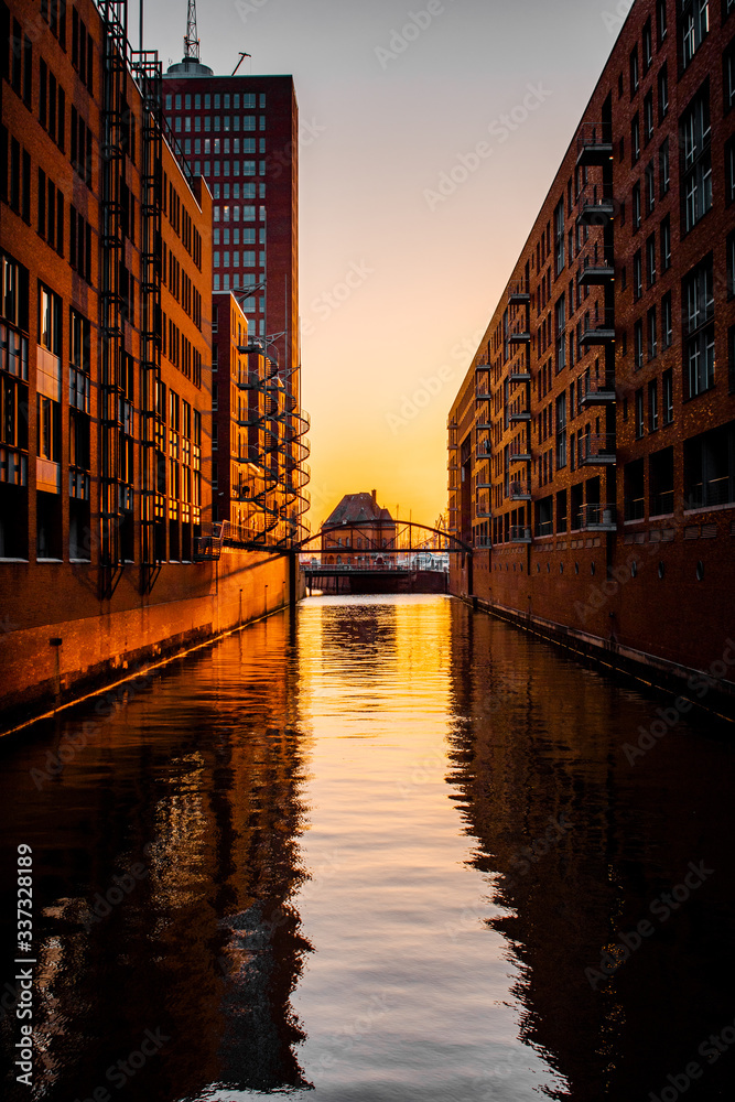 Beautiful sunset evening light in the water channels of the historic harbour district Speicherstadt in Hamburg, Europe