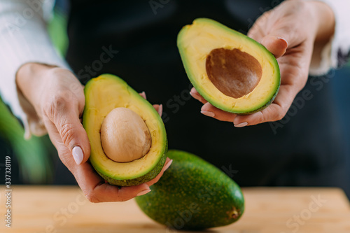 Cutting fresh, organic avocado, superfood rich in monosaturated fat, vitamins, minerals, fibers and phytonutrients photo