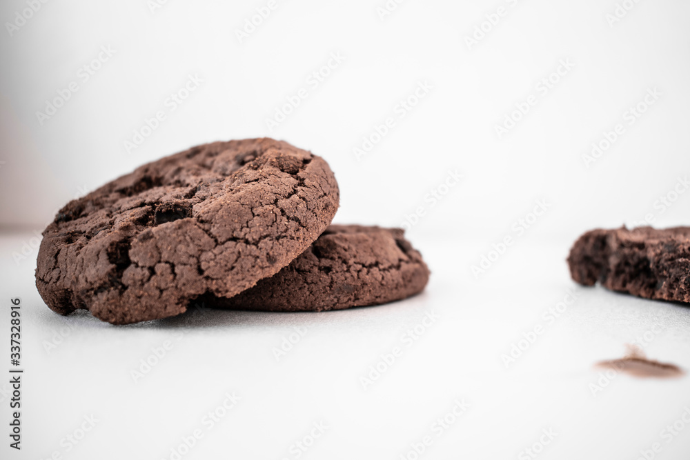 Two chocolate chip cookies on a white table Two chocolate chip cookies on a white table