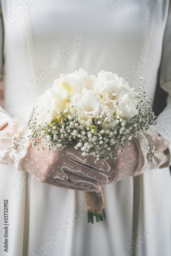  bride holds a wedding bouquet with different flowers  with white gloves. Close up flower