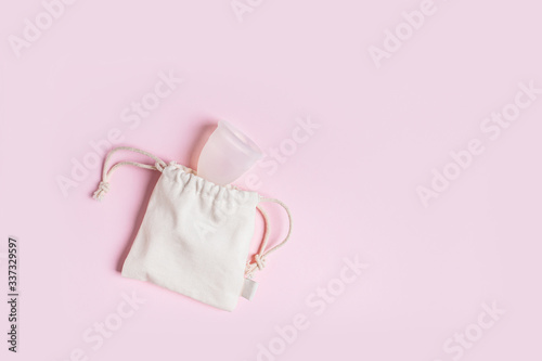 Silicone menstrual cup in a cotton bag. Reusable Intimate Hygiene. photo