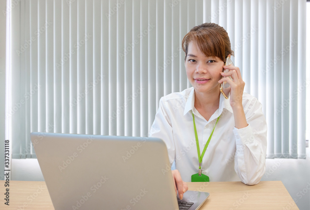 Smiling modern young asian business woman working with laptop at workplace Smiling modern young asian business woman working with laptop at workplace