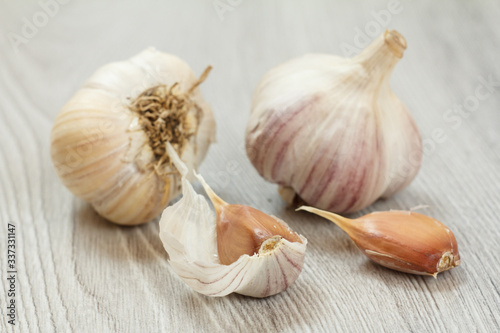 Raw garlic bulbs on a gray wooden background.
