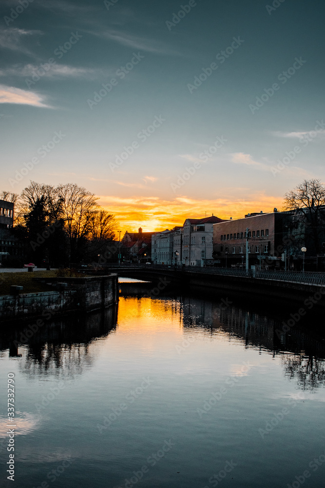 River in the downtown district at colorful moody evening sunset light and water reflection. Calm and empty evening scene. Downtown of a city, Braunschweig , Germany