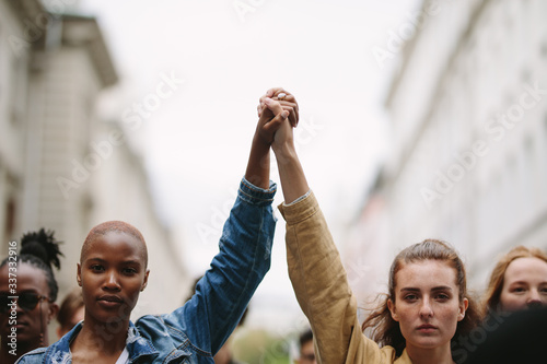 Group of activists with holding hands protesting photo