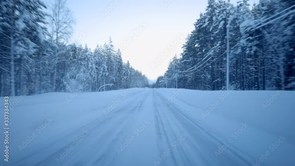 Point of View Shot of a Car Driving Down a Snow Covered Road in a Forest at Sunset Point of View Shot of a Car Driving Down a Snow Covered Road in a Forest at Sunset