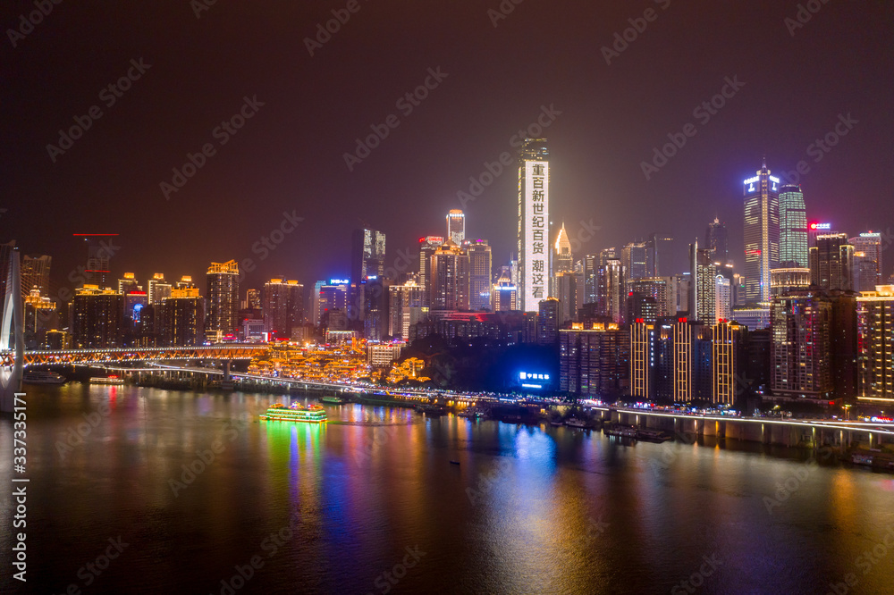 Fototapeta premium Aerial view of Hong Ya dong Cave, Historic Chinese folk religion town by Jialing River with lighted skyscrapers