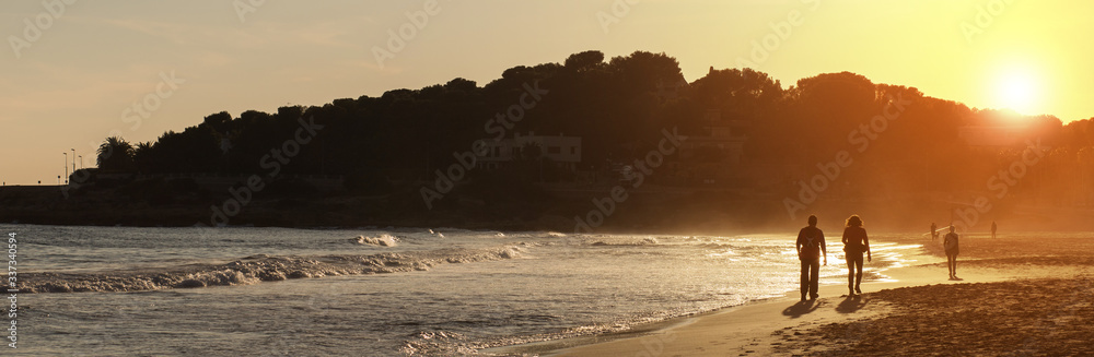 People leaving for the first time after pandemic confinement. Young people walking on the beach.