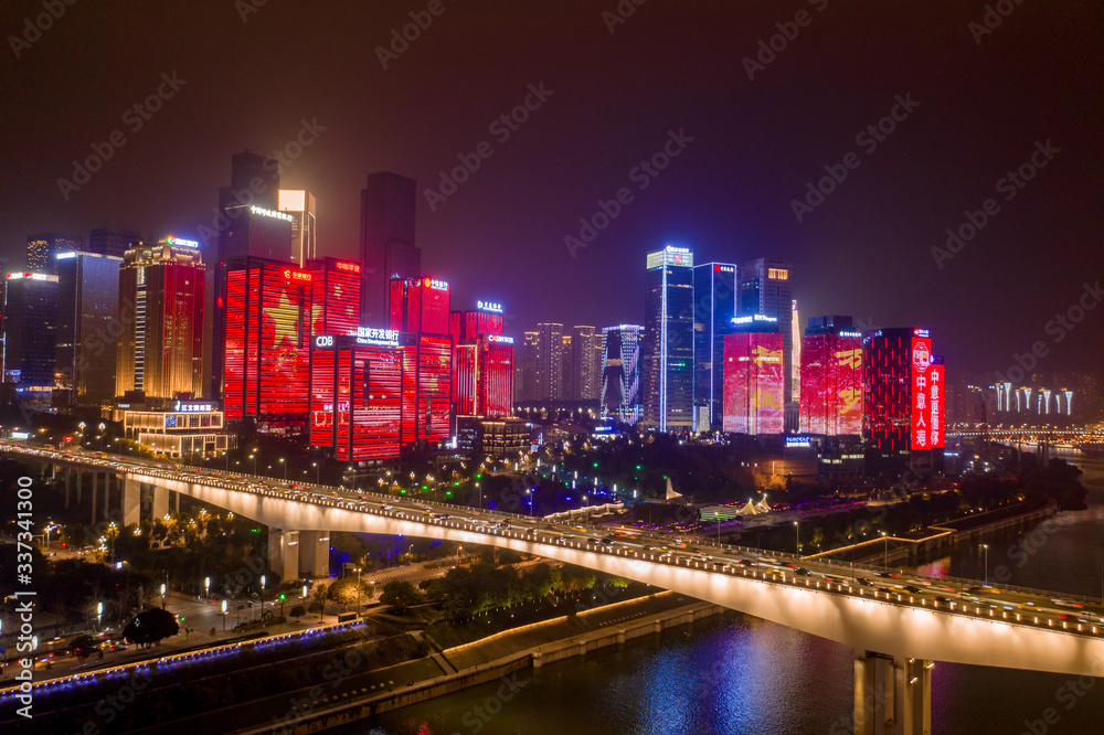 Fototapeta premium Aerial view of Huang Hua Yuan bridge over Jialing river by buildings with Chinese Flags on