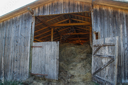 A large wooden rural barn where dry hay harvested for the winter is stored. Agriculture.