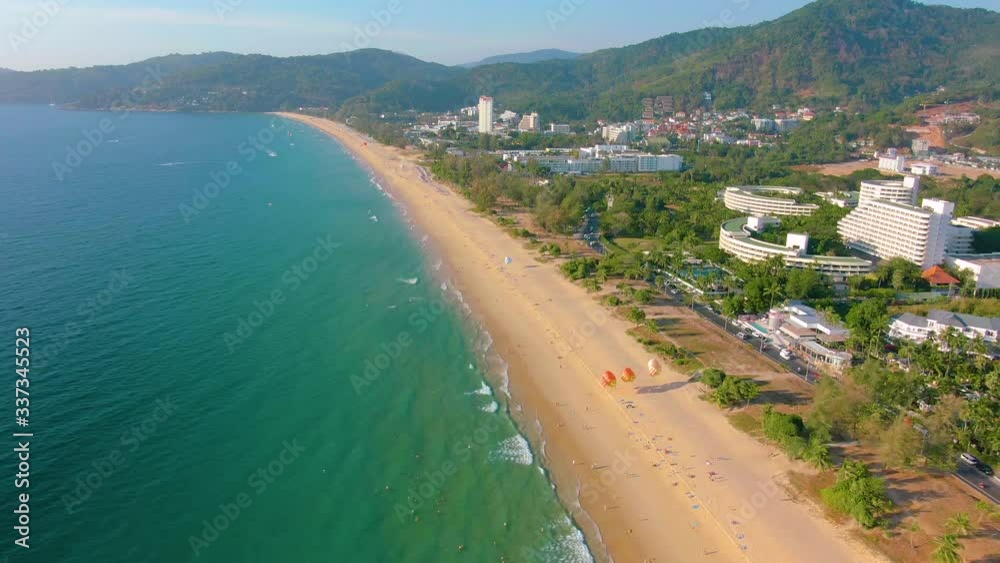 Aerial 4k view flying over tropical blue ocean towards beautiful green mountains and white sandy beach. Thailand. Phuket. Karon beach. Palms beach. Island top view. Beautiful resort place. Aerial 4k view flying over tropical blue ocean towards beautiful green mountains and white sandy beach. Thailand. Phuket. Karon beach. Palms beach. Island top view. Beautiful resort place.