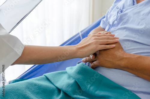 Wallpaper Mural coronavirus. friendly female doctor talking and keeping senior old patient hand lying on bed at hospital for encouragement, virus outbreak, quarantine, recovery, elderly, medical, health care concept Torontodigital.ca