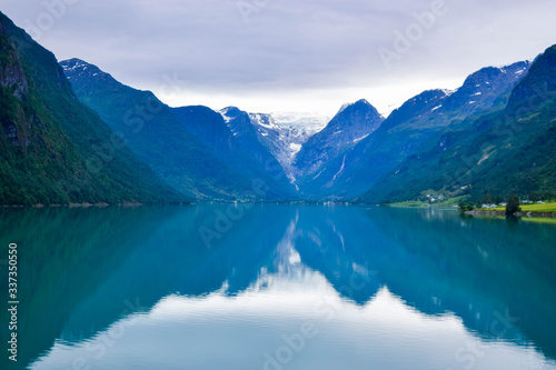 Fototapeta Naklejka Na Ścianę i Meble -  Landscape of beautiful Oldevatnet glacial lake and foggy mountains in which there are glaciers of Jostedalsbreen National Park. Norway.