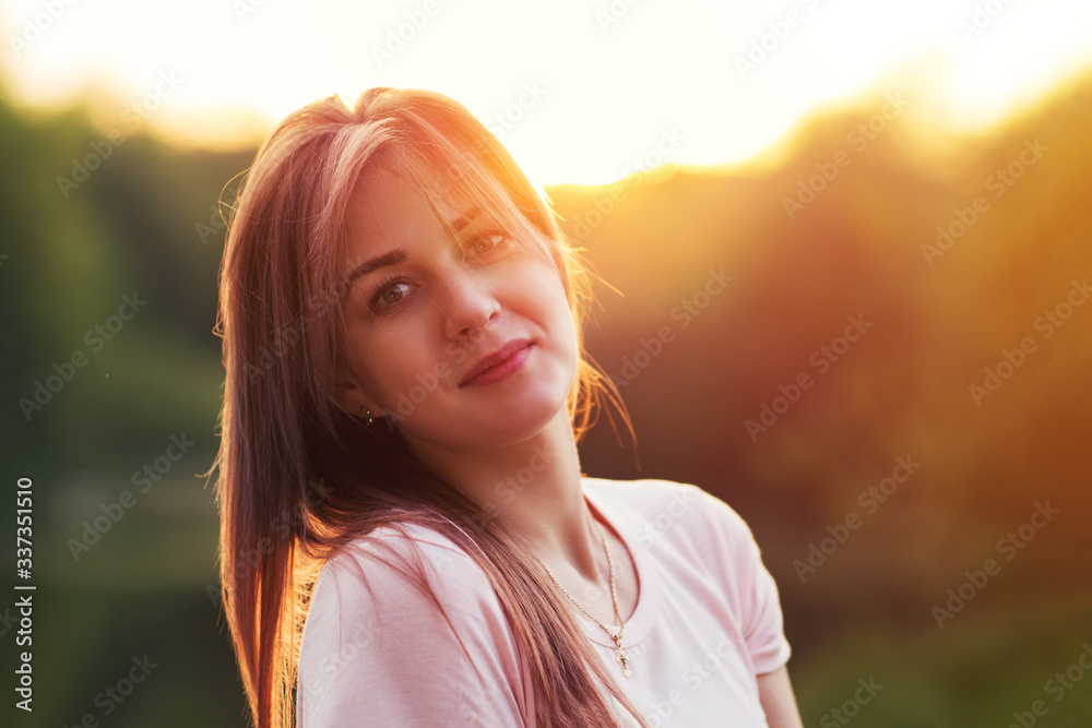 Portrait of a beautiful smiling young woman at sunset