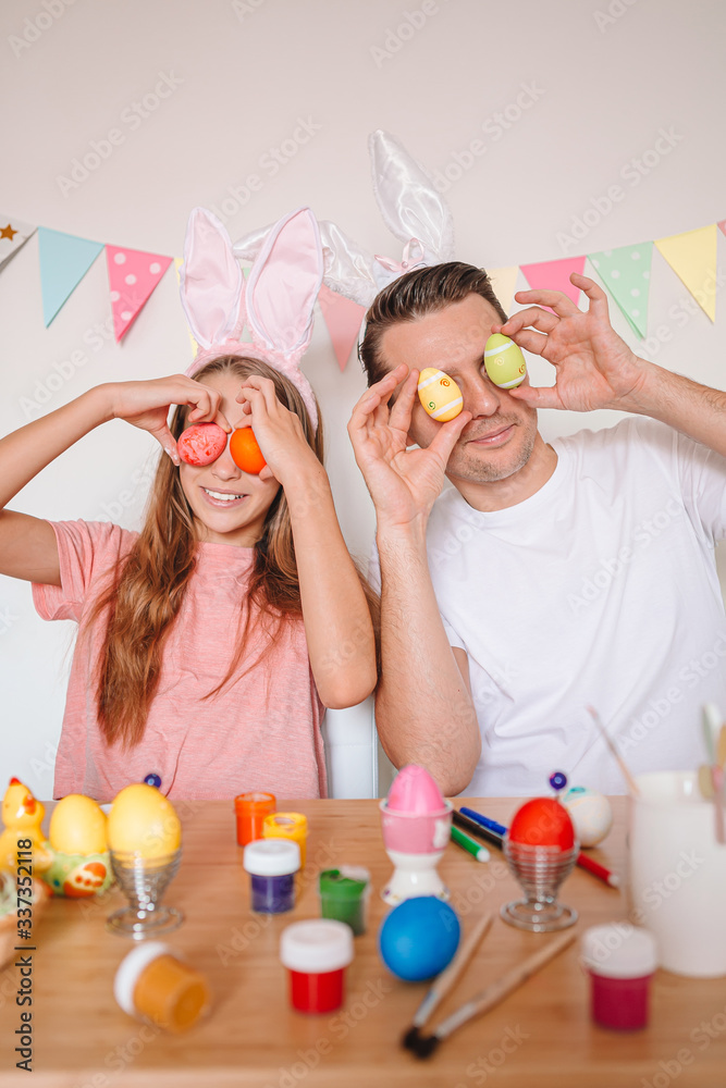Father and his little daughter painting eggs. Happy family preparing for Easter. Father and his little daughter painting eggs. Happy family preparing for Easter.