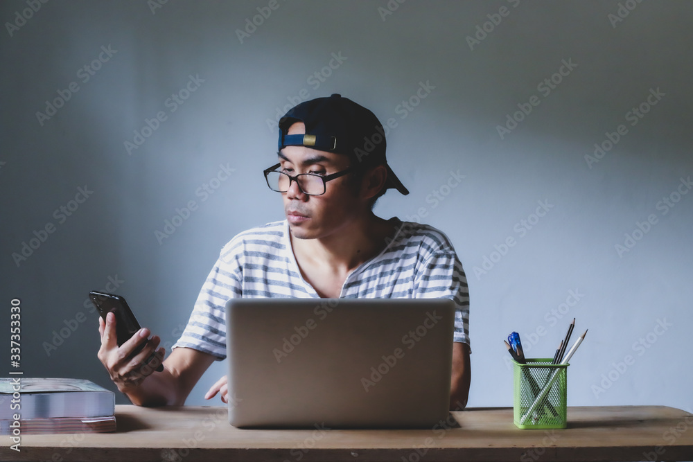Asian man working from hone online because of covid-19. Work at home and social distancing concept. Selective focus. Asian man working from hone online because of covid-19. Work at home and social distancing concept. Selective focus.