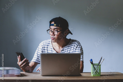 Asian man working from hone online because of covid-19. Work at home and social distancing concept. Selective focus.