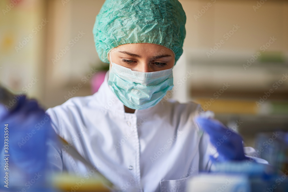 Woman in lab with protective gear working Woman in lab with protective gear working
