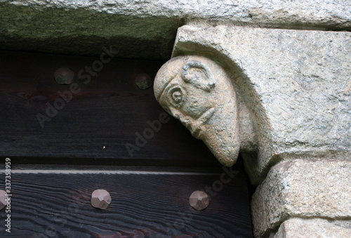 Schweiz, Tessin, Giornico, Romanische Kirche San Nicolao, Darstellung eines Kopfes oberhalb einer Eingangstür photo