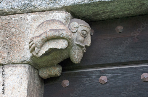 Schweiz, Tessin, Giornico, Romanische Kirche San Nicolao, Darstellung einer lasttragenden Figur oberhalb einer Eingangstür photo