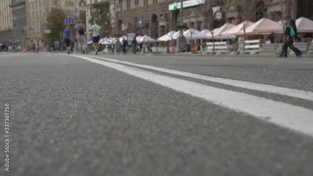 Road marking double line city street unrecognizable pedestrians camera movement slow motion