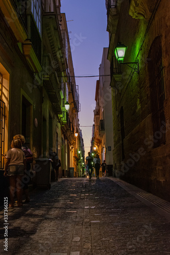 Anonymous people walking down the street with sunset sky, old town, Cadiz, Spain, Europe
