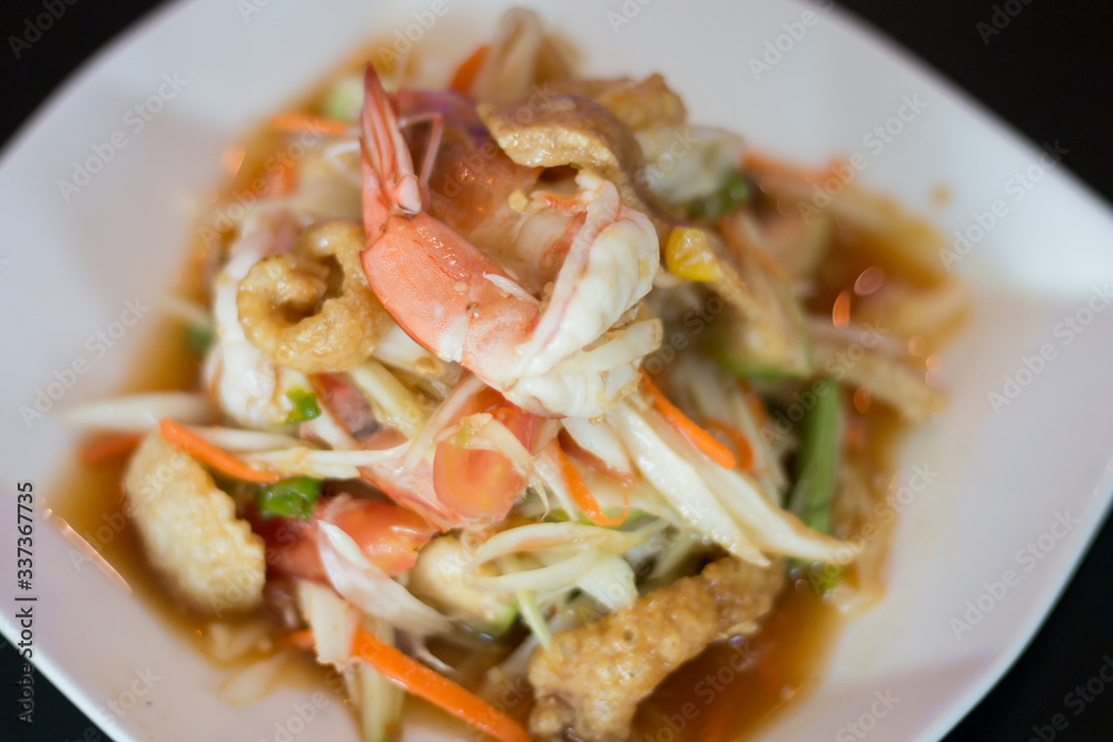 Thai papaya salad with fresh shrimp and crispy pork skin, a popular food for Thai people Thai papaya salad with fresh shrimp and crispy pork skin, a popular food for Thai people