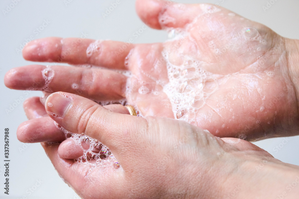 Hygiene and protection of hands from viruses (coronavirus) and bacteria using soap. The process of properly washing hands and fingers with soap foamed with water close-up on a white background Hygiene and protection of hands from viruses (coronavirus) and bacteria using soap. The process of properly washing hands and fingers with soap foamed with water close-up on a white background