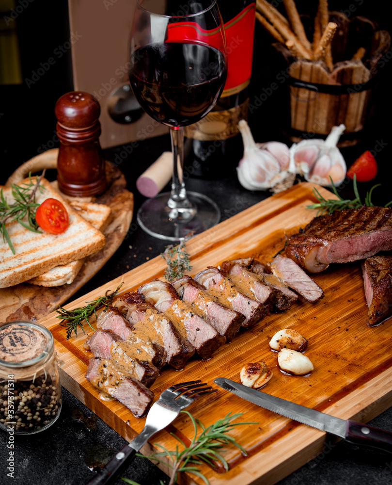Φωτογραφία chopped pieces of steak on a wooden board and garlic