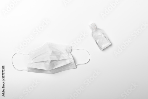 Sterilized medical face mask and antiseptic hand sanitizer on white background. Healthcare basic equipment for battle of Covid-19 epidemic.