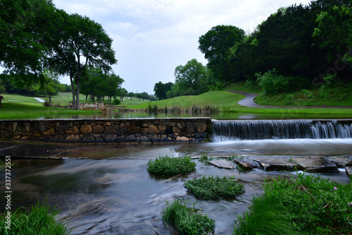 Gold course cart path crossing a small stream late in the evening after a rain shower in Leander TX. 