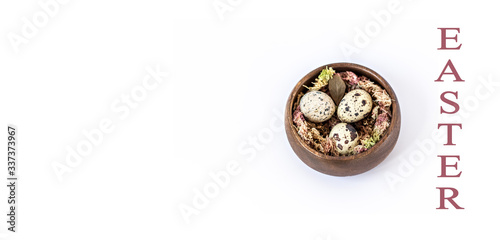 Easter quail eggs in a wooden bowl on a white background. Catholic and Orthodox Easter. In English, the inscription "Easter"