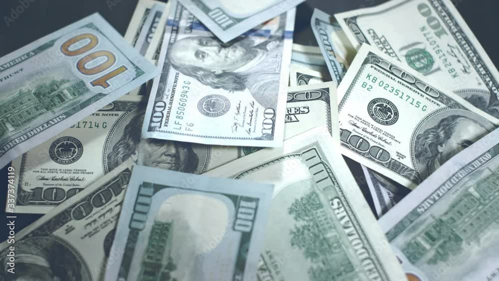Many american dollars are spinning. Green American money is on the table. American financial system. Rotating background of money dollars usa close up Many american dollars are spinning. Green American money is on the table. American financial system. Rotating background of money dollars usa close up