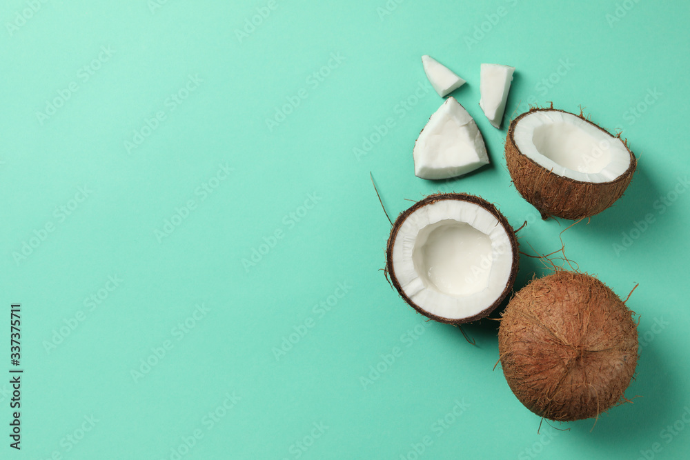 Coconut on mint background, top view and space for text
