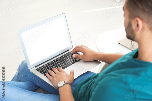 Young man using modern computer at home, focus on hands. Space for design